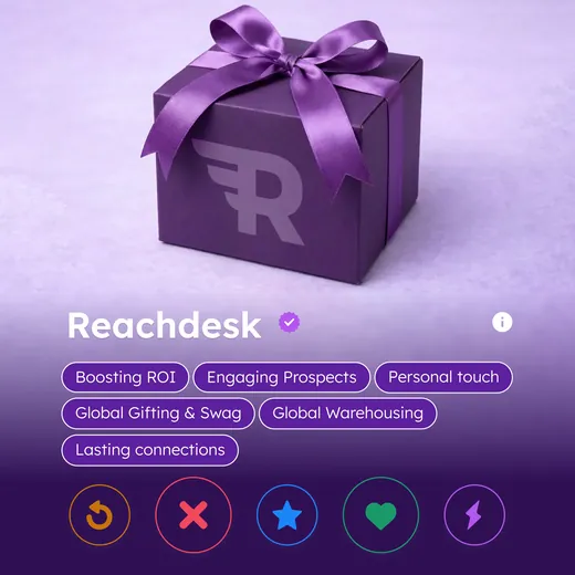Reachdesk ad styled as a dating app profile card, showing a purple branded gift box above the verified name Reachdesk and interest tags reading Boosting ROI, Engaging Prospects and Global Gifting and Swag